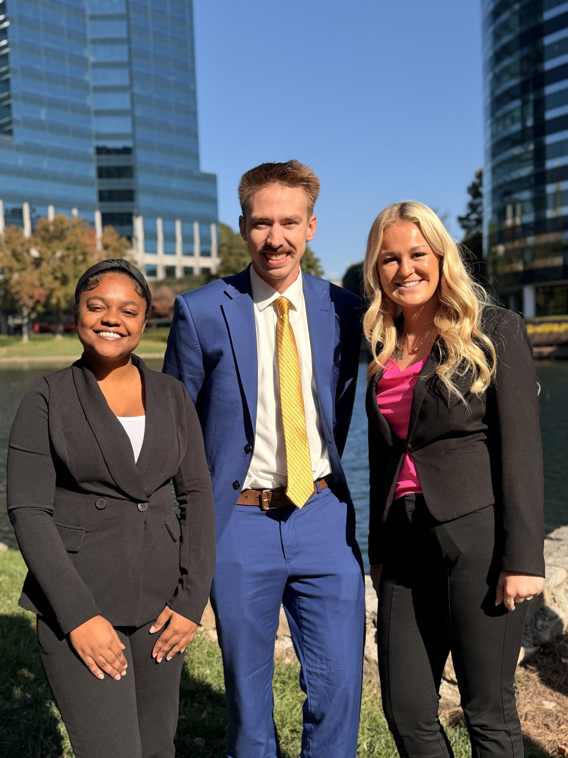 A marketing intern pictured alongside colleagues by a city skyline.